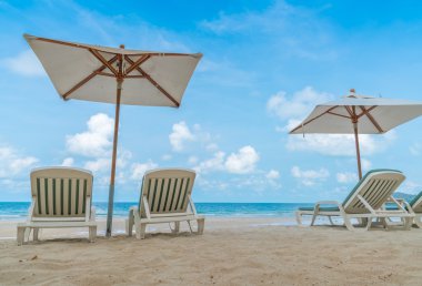 Güzel plaj sandalyeleri tropikal beyaz kum beac şemsiyesi ile