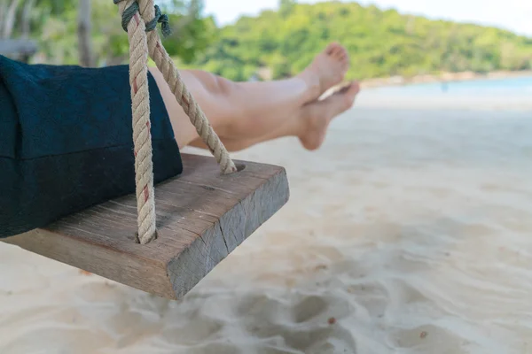 Frauenbein auf Schaukel am Strand des tropischen Meeres — Stockfoto