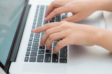 Laptop klavyesinde yazan kişi
