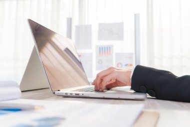 Laptop klavyesinde yazan kişi