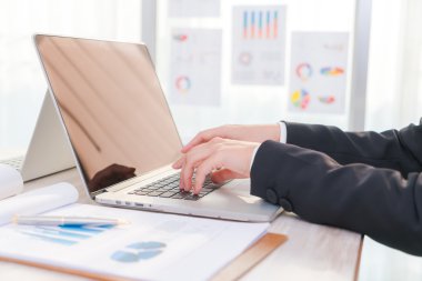 Laptop klavyesinde yazan kişi