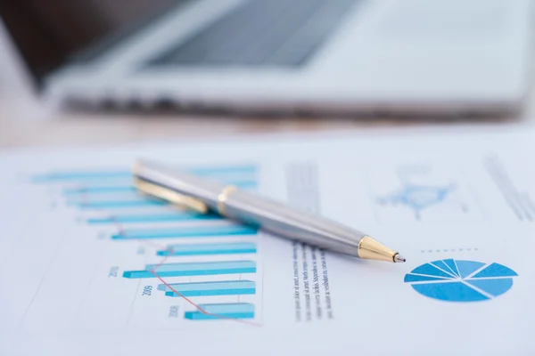 Financial charts on the table with lapto — Stock Photo, Image