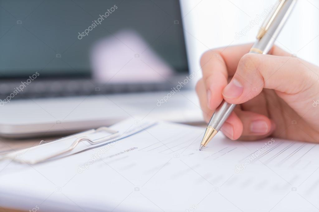 Hand with pen over application for