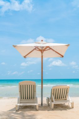 Güzel plaj sandalyeleri tropikal beyaz kum beac şemsiyesi ile