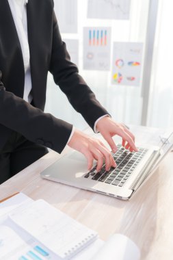 Laptop klavyesinde yazan kişi