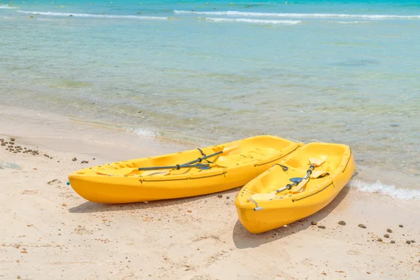 Yellow kayaks on white sand beac