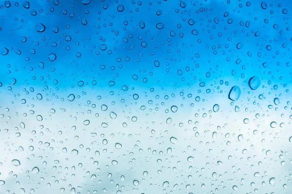 Droppar vatten på glasfönstret under blå himmel . — Stockfoto