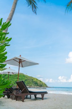 Güzel plaj sandalyeleri tropikal beyaz kum beac şemsiyesi ile