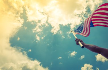 yıldızlar ve çizgiler ile Amerikan bayrağı eller blu karşı tutun