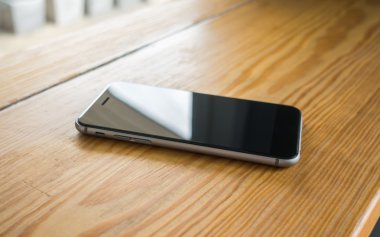 ahşap arka plan üstünde hareket eden telefon .