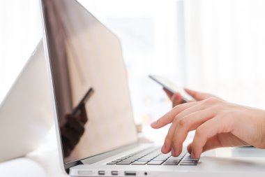Laptop klavyesinde yazan kişi