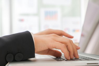Laptop klavyesinde yazan kişi