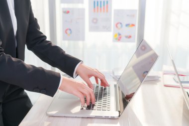 Laptop klavyesinde yazan kişi