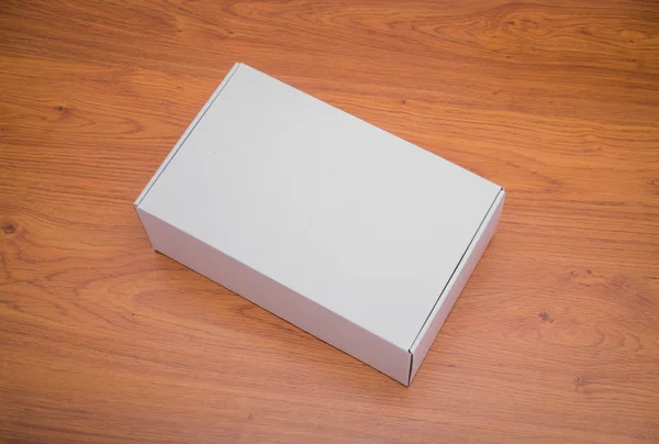 Caja blanca en blanco maqueta sobre fondo de madera —  Fotos de Stock