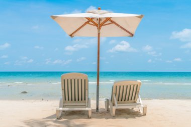 Güzel plaj sandalyeleri tropikal beyaz kum beac şemsiyesi ile