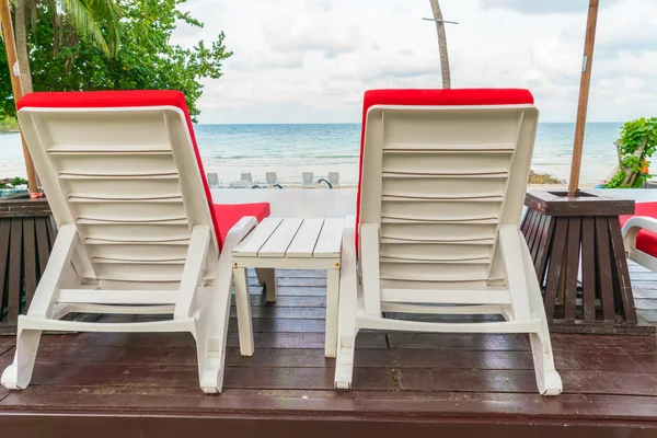 Красивые пляжные стулья с зонтиком вокруг открытых какашек — стоковое фото