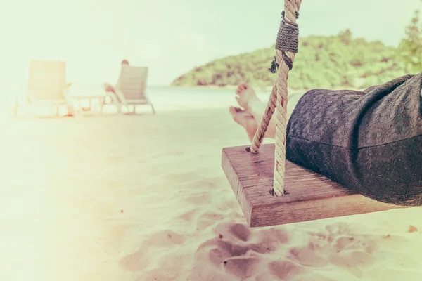 Jambe de femme sur une balançoire à la plage de la mer tropicale - Filtré image proc — Photo