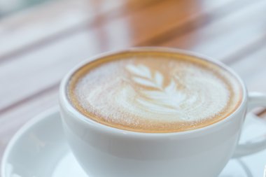 Ahşap masadaki Latte Kahve Sanatı