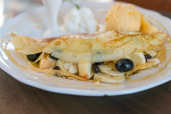 Pfannkuchen und Obst mit Eis auf dem Tisch . — Stockfoto