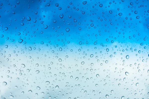 Краплі води на скляному вікні над блакитним небом  . — стокове фото