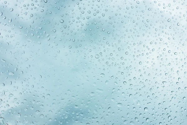 Gotas de água na janela de vidro sobre o céu azul  . — Fotografia de Stock