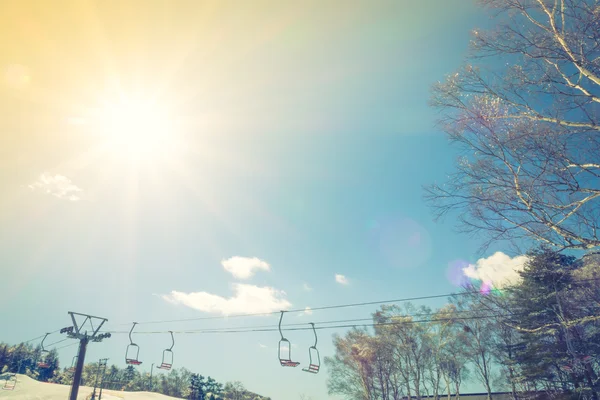 Pôr do sol e elevador de esqui passando sobre a montanha (imagem filtrada pr — Fotografia de Stock