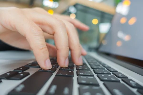 Primo piano della mano della donna d'affari che digita sulla tastiera del computer portatile . — Foto Stock