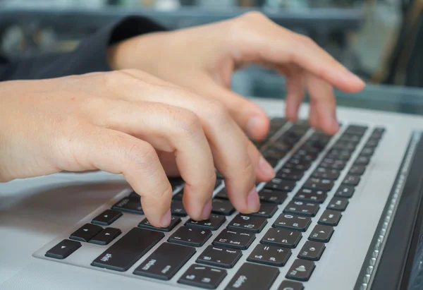 Primer plano de la mujer de negocios escribiendo a mano en el teclado del ordenador portátil . — Foto de Stock