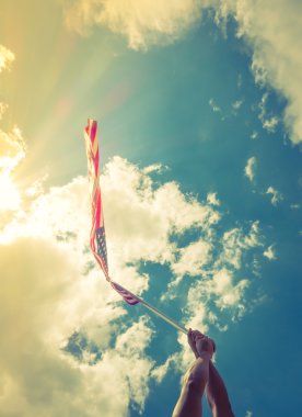 yıldızlar ve çizgiler ile Amerikan bayrağı eller blu karşı tutun