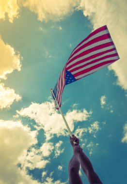 yıldızlar ve çizgiler ile Amerikan bayrağı eller blu karşı tutun