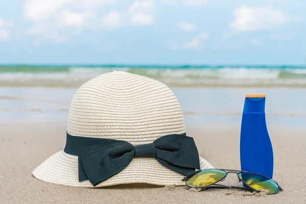 Sonnenbrille, Sonnencreme und Hut am weißen Sandstrand — Stockfoto