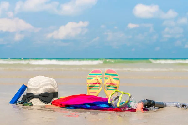 Sunglasses, sun cream and hat  on white  sand beach — Stock Photo, Image