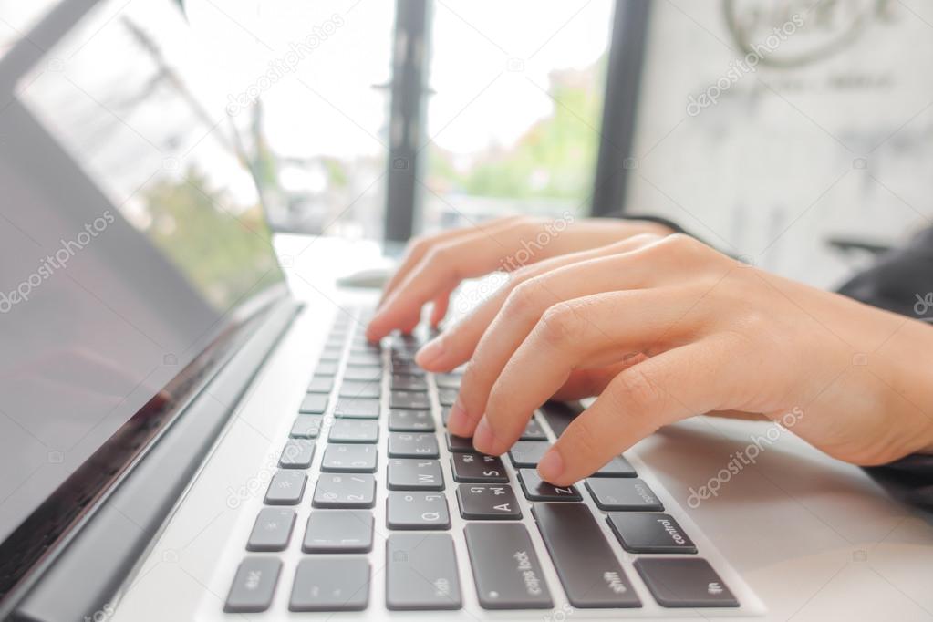 Closeup of business woman hand typing on laptop keyboard .