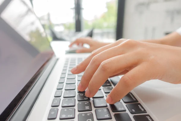 Primer plano de la mujer de negocios escribiendo a mano en el teclado del ordenador portátil . —  Fotos de Stock