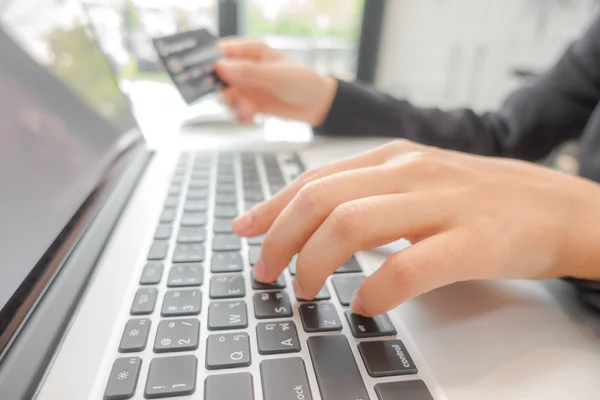 Händerna håller ett kreditkort och använder bärbar dator för online — Stockfoto