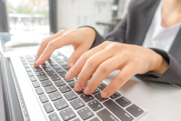 Primo piano della mano della donna d'affari che digita sulla tastiera del computer portatile . — Foto Stock