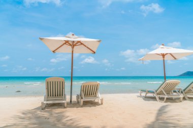 Güzel plaj sandalyeleri tropikal beyaz kum beac şemsiyesi ile