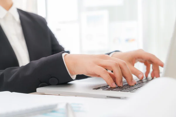 Primer plano de la mujer de negocios escribiendo a mano en el teclado del ordenador portátil — Foto de Stock