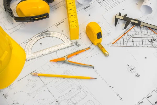 Planos de construção com capacete amarelo e ferramentas de desenho em bluep — Fotografia de Stock