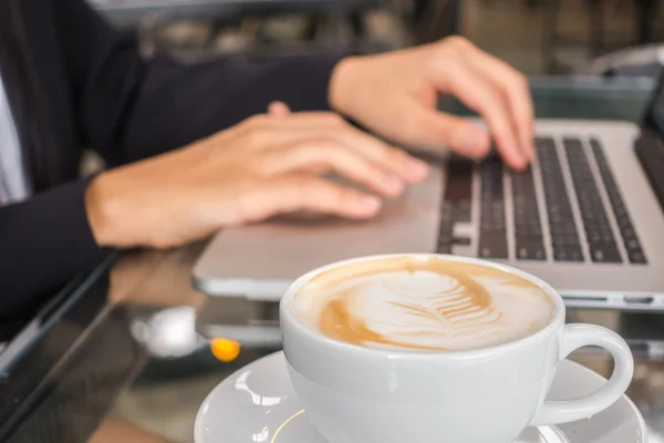 Gros plan de femme d'affaires tapant à la main sur le clavier de l'ordinateur portable et cof — Photo