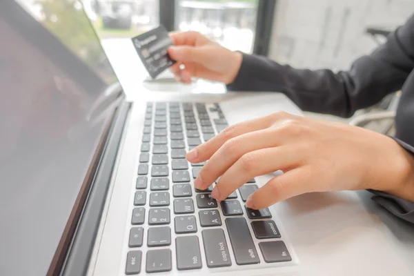 Hände, die eine Kreditkarte halten und Laptop-Computer für Online- — Stockfoto