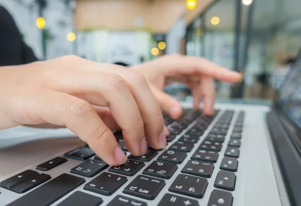 Primer plano de la mujer de negocios escribiendo a mano en el teclado del ordenador portátil . —  Fotos de Stock