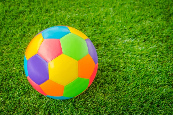 Gerçek deri renkli multi renk yeşil çimenlerin üzerinde futbol topu . — Stok fotoğraf