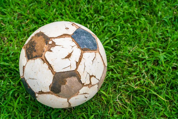 Old soccer ball on fresh spring green grass — Stock Photo, Image