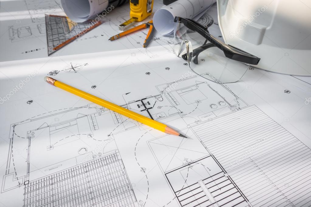 Construction plans with White helmet and drawing tools on bluepr