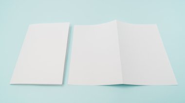 Bifold beyaz şablon kağıt üzerinde mavi arka plan .