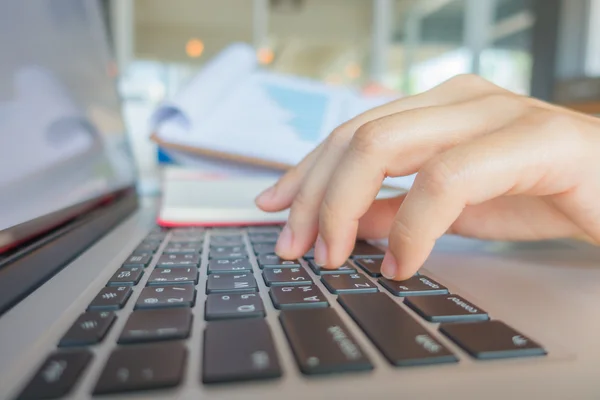 Primo piano della mano della donna d'affari che digita sulla tastiera del computer portatile . — Foto Stock