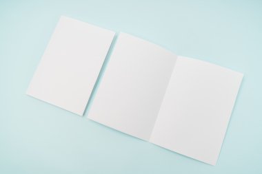 Bifold beyaz şablon kağıt üzerinde mavi arka plan .