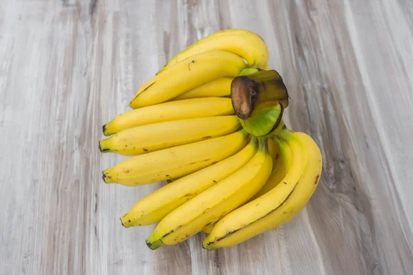 Plátanos frescos sobre mesa de madera . — Foto de Stock