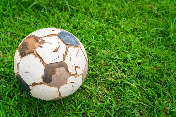 Old soccer ball on fresh spring green grass — Stock Photo, Image